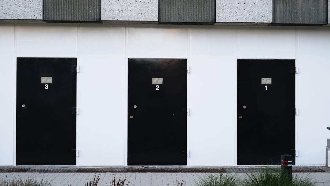 black-door-on-white-concrete-wall-ay3cdyqj4xu